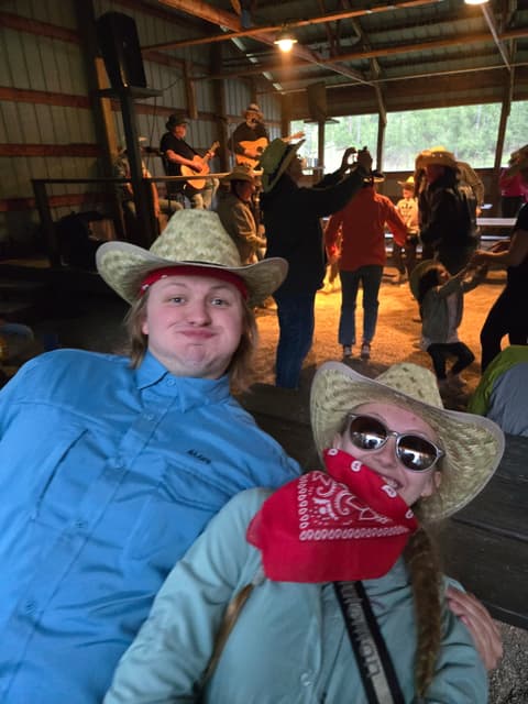 Finn and a friend in cowboy hats at an evening event