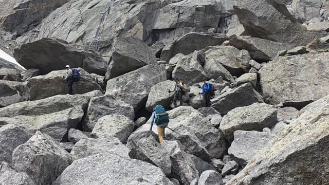 Hikers picking their way up a granite boulder field