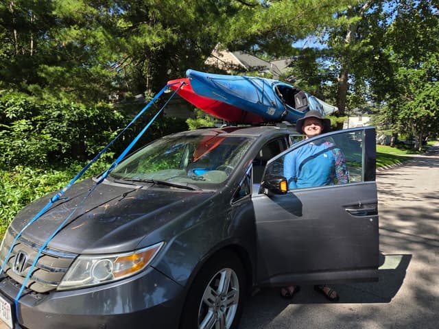 A kayak strapped to the roof of a minivan
